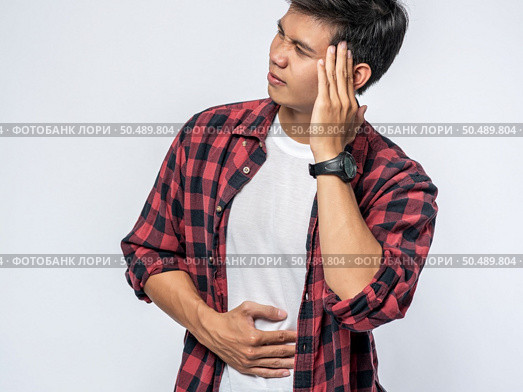 A man who is sick and touches his head with his hand. Стоковое фото, агентство Ingram Publishing / Фотобанк Лори