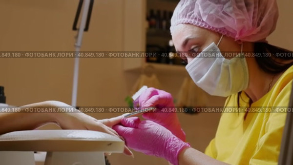 A manicurist makes gel nail extensions using a manicure brush (2021 год). Редакционное видео, видеограф Алексей Гекало / Фотобанк Лори