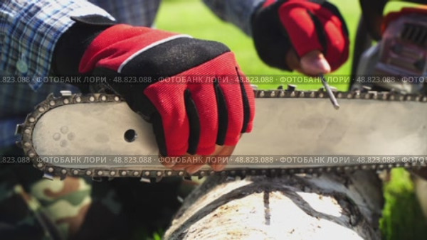 A master sharpens a chainsaw chain before work. Стоковое видео, видеограф Igor Skripachev / Фотобанк Лори
