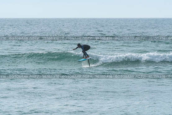 A middle aged man doing some foil surfing or hydrofoil surfing in the sea. Стоковое фото, агентство Ingram Publishing / Фотобанк Лори