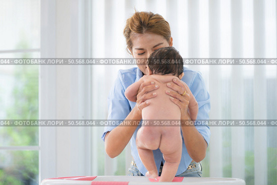 A mother bathes her little daughter in a small children’s tub. Стоковое фото, агентство Ingram Publishing / Фотобанк Лори