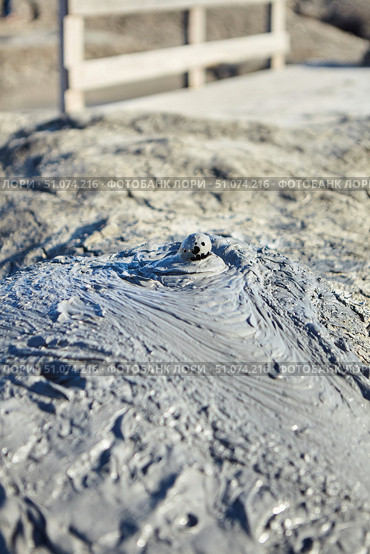 A mud volcano and a stream of grey clay from an eruption and gas escape. Cracked soil surface. Texture of a mudflow. Стоковое фото, фотограф Наталия Кирсанова / Фотобанк Лори