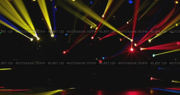 a multitude of multi-colored stage lights with narrow colored beams of light on a dark stage background. Стоковое AI-видео, аниматор Александр Довянский / Фотобанк Лори