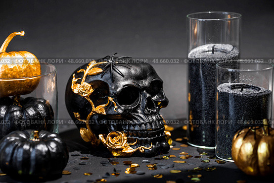 A mysterious black skull with golden roses and pumpkins for a Halloween or Day of the dead party on a black grunge background. Стоковое фото, фотограф Photojuli / Фотобанк Лори
