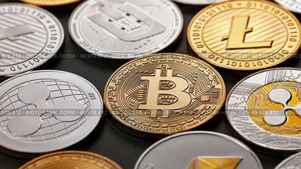 A pattern from different coins of crypto currency on a dark background. Gold and silver coins ripple, bitcoin, litecoin, ethereum, dash. Business concept. Top view. Close-up of shiny gold and silver coins on a dark background. Business and technology concept. Top view. Стоковое фото, агентство Ingram Publishing / Фотобанк Лори
