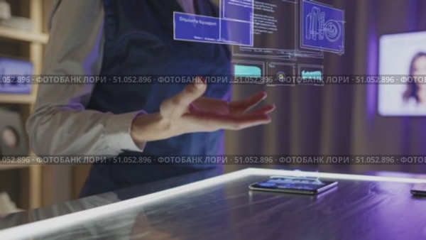 A Person Interacting with Advanced Holographic Technology Over a Smartphone, Showcasing Data Visualization and Information Analysis in a Modern Setting. Стоковое AI-видео, аниматор Владимир Федоров / Фотобанк Лори