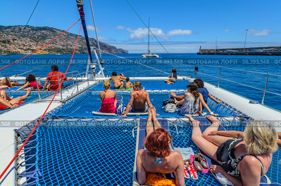 A pleasure catamaran with passengers set sail from Funchal Bay (2012 год). Редакционное фото, фотограф Михаил Аккуратoв / Фотобанк Лори