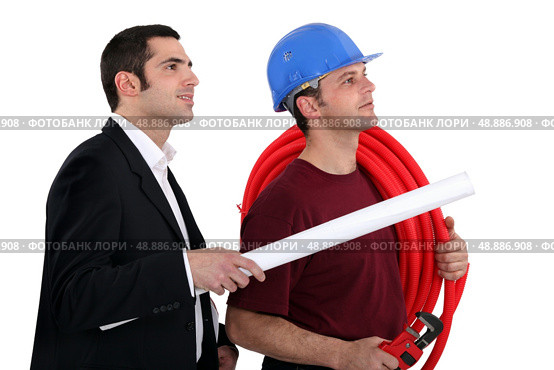 a plumber and a manager watching something. Стоковое фото, агентство Ingram Publishing / Фотобанк Лори