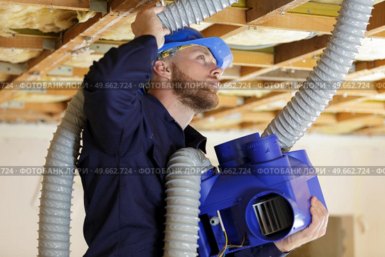 a plumber checking ceiling pipes. Стоковое фото, агентство Ingram Publishing / Фотобанк Лори
