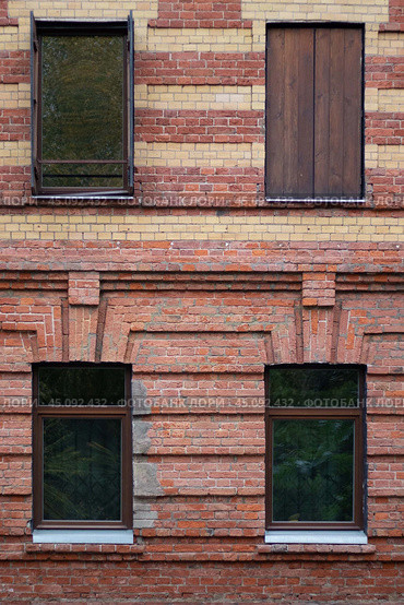 A red and yellow brick wall with four windows, three open and one closed, with wooden shutters. Стоковое фото, фотограф Маргарита Розова / Фотобанк Лори