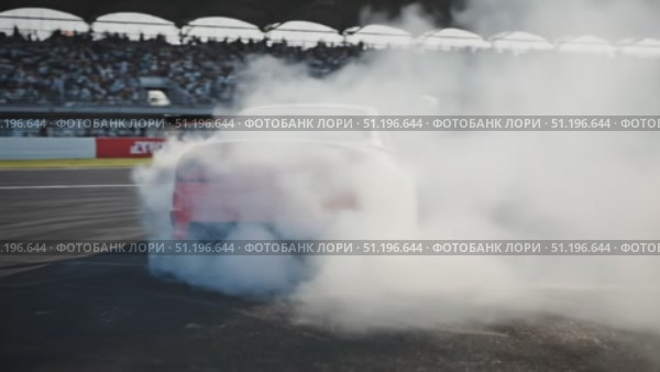 A red car makes a demonstration drift performance with thick smoke in front of the stadium stands. Стоковое AI-видео, аниматор Ярославский Максим / Фотобанк Лори
