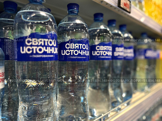 A row of water bottles of Saint Spring with Russian writing on them. Russia. Moscow. 08.08.25. Редакционное фото, фотограф Ярославский Максим / Фотобанк Лори