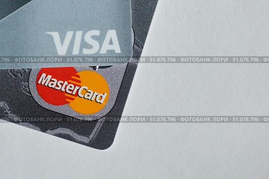 A set of Visa and Mastercard Bank credit cards lies on a white surface. The concept of the economy and the banking system, the financing (2020 год). Редакционное фото, фотограф Наталия Кирсанова / Фотобанк Лори
