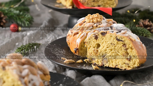 A slice of Bolo Rainha, a traditional Portuguese sweet bread, dusted with powdered sugar and adorned with almonds and walnuts. Стоковое фото, агентство Ingram Publishing / Фотобанк Лори