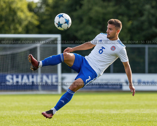 A soccer player in a blue and white uniform kicks a soccer ball. Стоковое AI-изображение, AI-художник Ярославский Максим / Фотобанк Лори