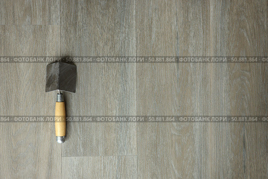 A spatula for corners on a laminated grey background. Repair concept, repair goods stores. Top down view. Copy space. Стоковое фото, фотограф Екатерина Топорова / Фотобанк Лори