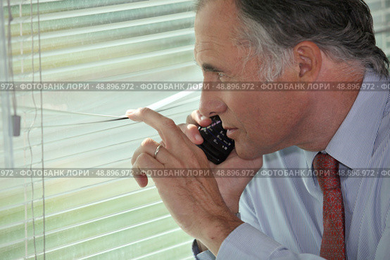 A spy peering through some blinds. Стоковое фото, агентство Ingram Publishing / Фотобанк Лори