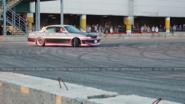 A strong sideways skid of the car in front of visitors at the Mega Belaya Dacha site. The skill of driving a drift car. Russia. Moscow. 19.05.2024. Стоковое видео, видеограф Ярославский Максим / Фотобанк Лори