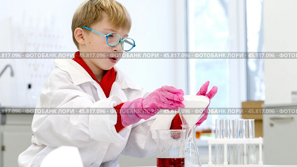 a student in a chemical laboratory conducts chemical sweats with chemical elements in. Стоковое фото, фотограф Igor Skripachev / Фотобанк Лори