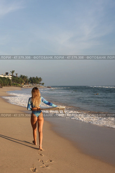 A Surfer Eagerly Prepared to Ride the Cresting Waves on a Stunningly Beautiful Beachside. Стоковое фото, фотограф Женя Канашкин / Фотобанк Лори