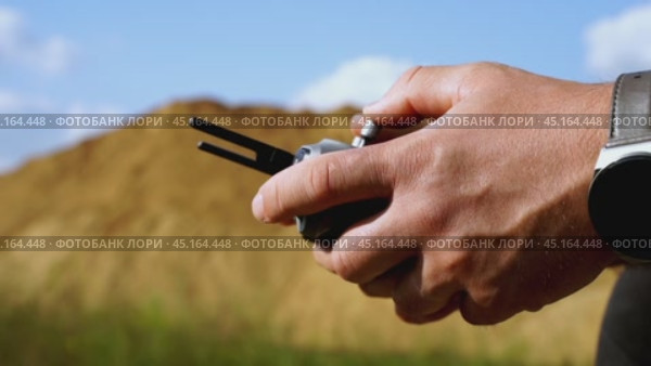 a surveyor on a construction site controls a quadcopter. Стоковое видео, видеограф Igor Skripachev / Фотобанк Лори