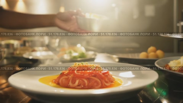 A talented chef skillfully plates a vibrant pasta dish while surrounded by an elegant kitchen atmosphere and culinary tools. Стоковое AI-видео, аниматор Данила Большаков / Фотобанк Лори