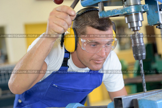 a technician is drilling steel. Стоковое фото, агентство Ingram Publishing / Фотобанк Лори