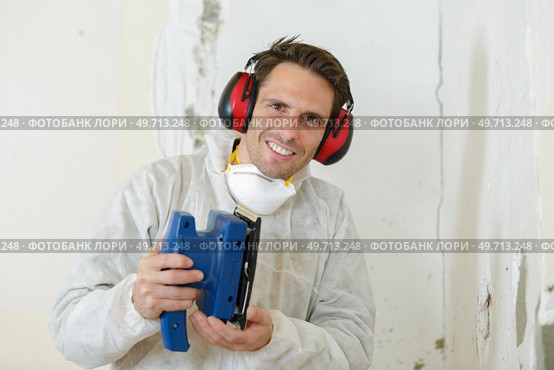 a tradesman holding sander machine. Стоковое фото, агентство Ingram Publishing / Фотобанк Лори