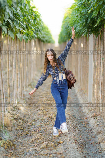 A trendy young woman experiences a whimsical and joyful moment in a stunning vineyard, surrounded by lush and vibrant greenery, creating a captivating scene filled with happiness and delight. A stylish young woman dances joyfully in a scenic vineyard, surrounded by vibrant nature. Стоковое фото, агентство Ingram Publishing / Фотобанк Лори