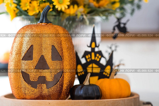 A vase of flowers, pumpkins and a scary castle with a witch on the background of a Scandi-style white kitchen interior. The concept of home and comfort. Autumn decor for Halloween. Стоковое фото, фотограф Photojuli / Фотобанк Лори