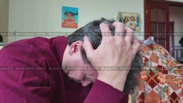 A very tired man in a room on an armchair. Стоковое видео, видеограф Виктор Тихонов / Фотобанк Лори