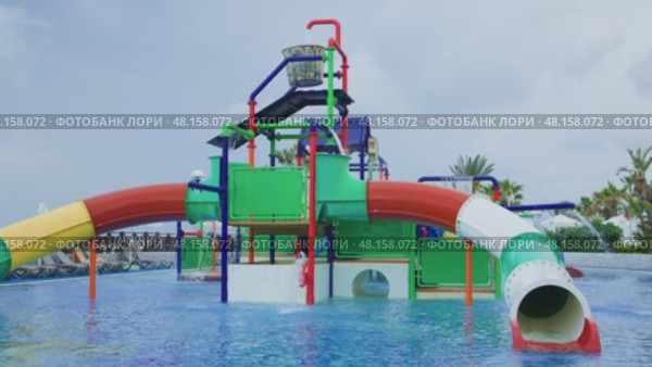 A Vibrantly Colorful Water Play Structure Featuring Exciting Slides Inside a Pool Area. Стоковое видео, видеограф Olesia Kondrateva / Фотобанк Лори