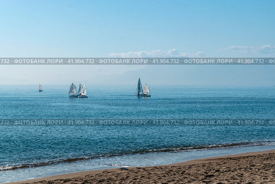 A view from the shore of the yacht team at sea in class. Muratpasha. Antalya. Turkey. 04.01.2023 (2022 год). Редакционное фото, фотограф Ярославский Максим / Фотобанк Лори
