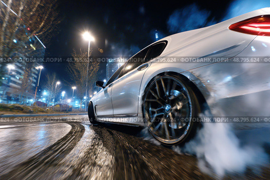 A white car is driving down a wet road with smoke coming out of its back. Стоковое AI-изображение, AI-художник Ярославский Максим / Фотобанк Лори
