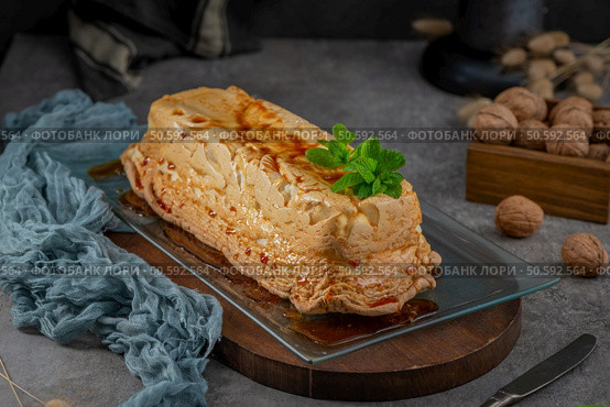 A whole molotof, a traditional caramelized egg white pudding, generously drizzled with sweet syrup and garnished with fresh mint leaves, is presented on a glass serving tray. Стоковое фото, агентство Ingram Publishing / Фотобанк Лори