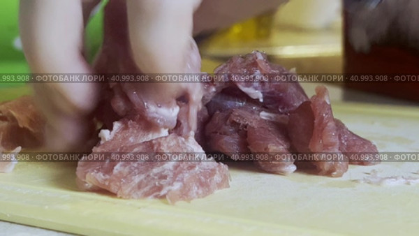 A woman cuts fresh beef on a kitchen board. Focus on pieces of meat and hands with a knife. Стоковое видео, видеограф Ярославский Максим / Фотобанк Лори