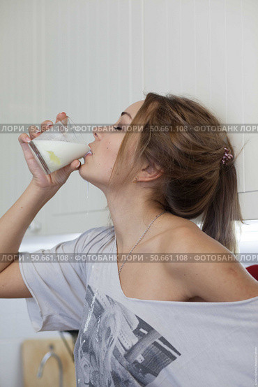 A woman drinks milk and spills on her neck. Стоковое фото, фотограф Роготнева Виктория / Фотобанк Лори