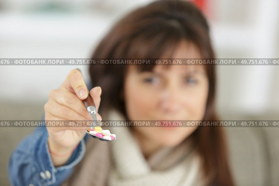 a woman eating pills tablets. Стоковое фото, агентство Ingram Publishing / Фотобанк Лори