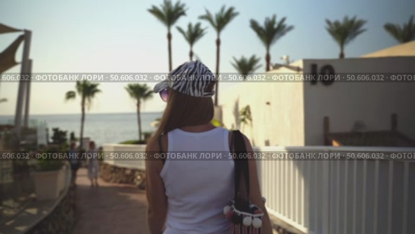 A woman goes to the beach to the sea on the hotel territory. Стоковое видео, видеограф Igor Skripachev / Фотобанк Лори