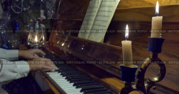 A woman plays the piano in the light of candles and kerosene lamp. Стоковое видео, видеограф Сергей Медведев / Фотобанк Лори