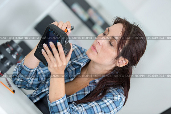 a woman repairing electrical device. Стоковое фото, агентство Ingram Publishing / Фотобанк Лори