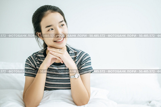 A woman sat with his hands rested under the chin and smiled happily. Стоковое фото, агентство Ingram Publishing / Фотобанк Лори