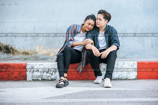 A woman sitting on each other’s shoulders by the road. Стоковое фото, агентство Ingram Publishing / Фотобанк Лори