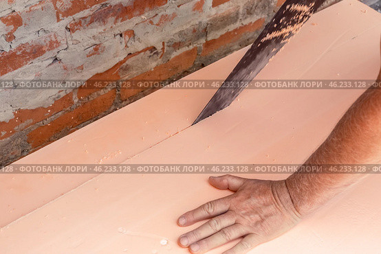 A worker cuts polystyrene foam for laying on the floor. Insulation of the house, installation of a heated floor. Стоковое фото, фотограф Коханова Наталья / Фотобанк Лори