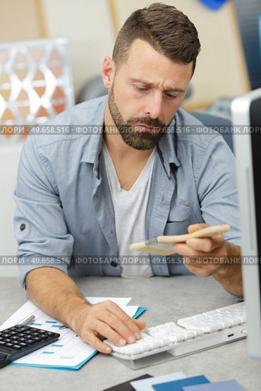 a young man checking references. Стоковое фото, агентство Ingram Publishing / Фотобанк Лори