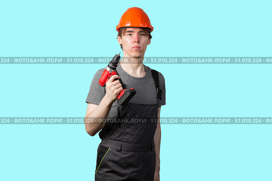 A young man with a screwdriver for construction work. Insulate. Стоковое фото, фотограф Александр Поташев / Фотобанк Лори