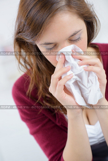 a young woman is sneezing. Стоковое фото, агентство Ingram Publishing / Фотобанк Лори