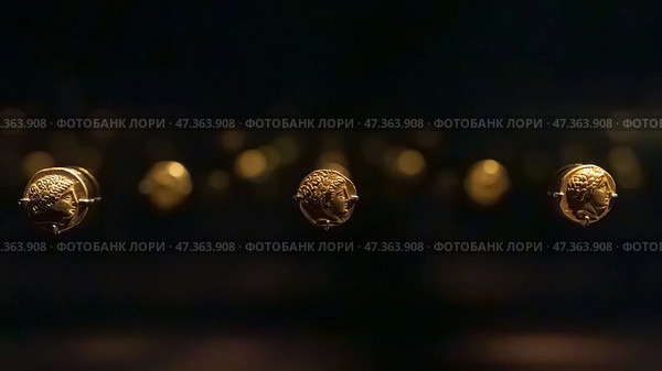 Abu Dhabi, United Arab Emirates - Jan 17 2024, Close-up view of the ancient antique coins in the Louvre Abu Dhabi Museum, belonging to different eras, Abu Dhabi, United Arab Emirates. Редакционное фото, фотограф Сергей Богомяко / Фотобанк Лори