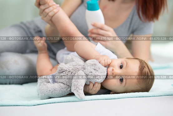 adorable baby layed on the floor chewing teddy. Стоковое фото, агентство Ingram Publishing / Фотобанк Лори