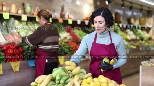 Adult woman seller puts bananas on display. Стоковое видео, видеограф Яков Филимонов / Фотобанк Лори